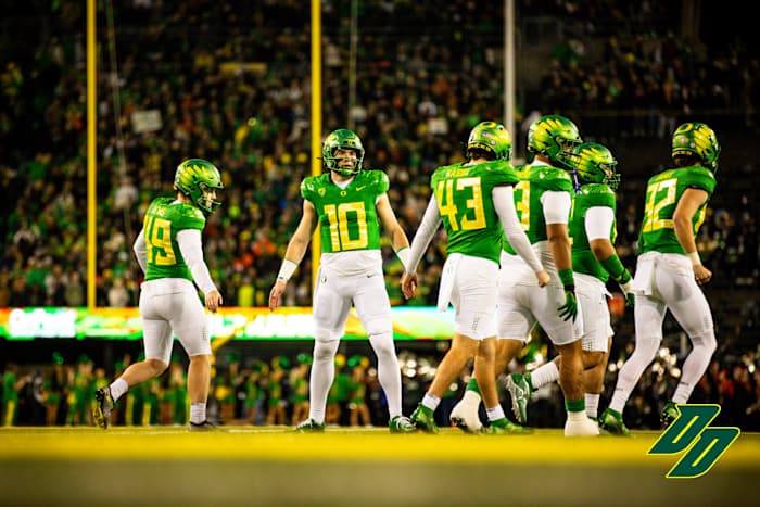 Oregon Ducks quarterback Bo Nix high-fives teammates in a game against the Oregon State Beavers.